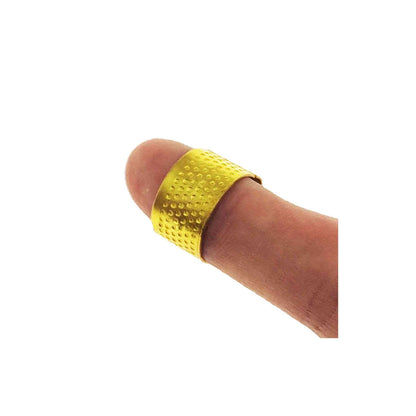 Yellow metal thimble ring displayed on a finger on a white background